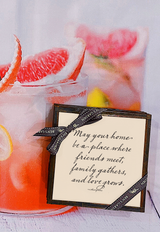 May Your Home copper and glass coaster set tied with Ben’s Garden ribbon beside pink citrus cocktails